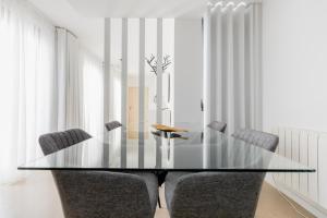 a dining room with a glass table and chairs at Castle Palm View in Leiria