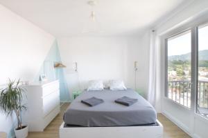 a white bedroom with a bed and a large window at Studio 4 Swimming pool summer parking & superb view! in Aix-les-Bains