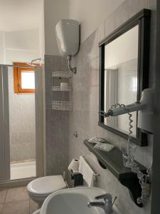 un bagno con lavandino, specchio e WC di B&B Dalla Nonna a Mattinata