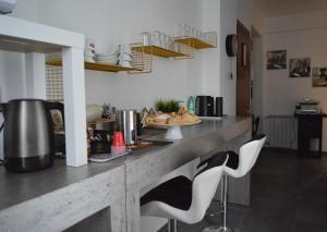 a kitchen with a counter and two white chairs at B&B SERENITY2024 in Rome
