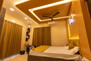 a room with a bed with a ceiling fan at Lavender Heights in Lonavala