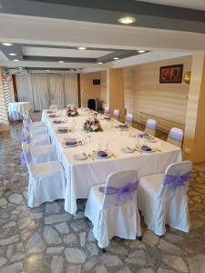 una gran sala de banquetes con mesas blancas y sillas blancas. en Hotel Nicolás Temuco, en Temuco