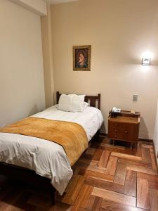 a small bedroom with a bed and a night stand at El Virrey Boutique in Cusco