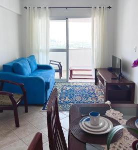 een woonkamer met een blauwe bank en een tafel bij Pérola do Aquarius III in São José dos Campos