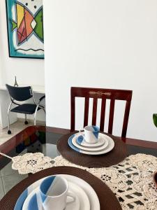 una mesa con platos y tazas encima en Pérola do Aquarius III, en São José dos Campos