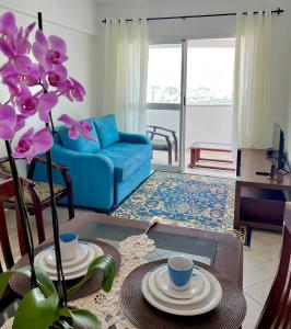 een woonkamer met een tafel en een blauwe bank bij Pérola do Aquarius III in São José dos Campos