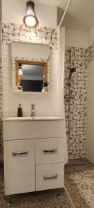 ein Bad mit einem Waschbecken, einem Spiegel und einer Dusche in der Unterkunft Residence Angelina in Arad