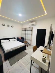 a bedroom with a bed and a desk with a computer at AD HOME in Lomé