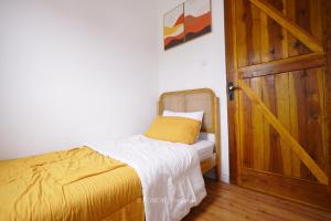 Habitación pequeña con cama y puerta de madera en RUMAH BIRU en Bandung