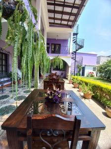 un patio con mesa, sillas y plantas en Hotel Quinta Vista Verde, en Antigua Guatemala