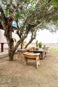 a group of benches sitting under a tree at Car in the garage and everything on foot. in Búzios