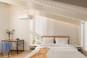 1 dormitorio con 1 cama grande y 1 mesa en Giustiniani Apartments, en Chios