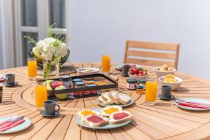 una mesa con alimentos para el desayuno y zumo de naranja en ella en Giustiniani Apartments, en Chios
