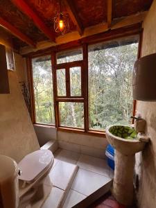 a bathroom with a window and a sink and a toilet at La Cabaña Musical in Medellín