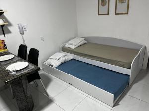 a small room with a bed and a table at Charme do Residence in Natal