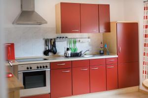 a kitchen with red cabinets and a red refrigerator at Ferienwohnung Spiegelberg in Spiegelberg