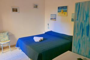 a bedroom with a blue bed with towels on it at Casa Stelle Marine in Palau