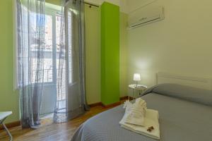 a bedroom with green walls and a bed and a window at Case Spazioscena - Tàlia in Castelbuono