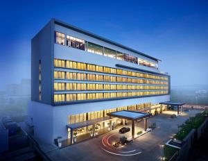 ein großes Gebäude mit einem Parkplatz davor in der Unterkunft Vivanta Pune, Hinjawadi in Pune