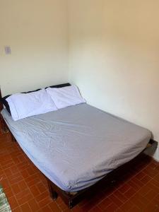 Ένα ή περισσότερα κρεβάτια σε δωμάτιο στο Casinha 4 quadras da praia com churrasqueira e garagem