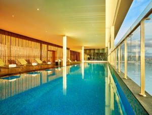 a large swimming pool in a hotel with a view at Vivanta Pune, Hinjawadi in Pune