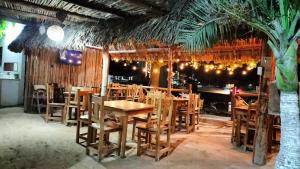 a restaurant with wooden tables and chairs and a palm tree at HOTEL LAS COLORADAS in Yuluc