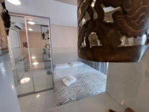 a small bathroom with a bed and a shower at Book Santos Unlimited 817 Elegancia Vista Mar in Santos