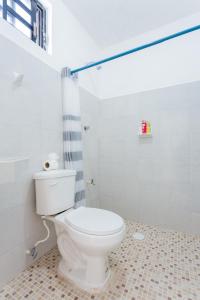 a bathroom with a white toilet and a shower at HOTEL LAS COLORADAS in Yuluc