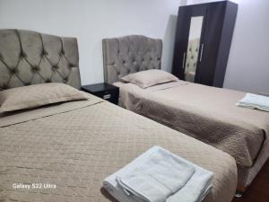 a bedroom with two beds and a mirror at Villa Paraiso Apart in Cusco