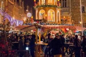 una multitud de personas caminando por un mercado de Navidad en Golden Apartments &Uniwersytecka, en Wroclaw