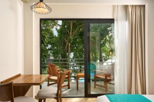 a dining room with a table and chairs on a balcony at Cristalino Lagoon Front Hotel, Restaurant & Spa in Bacalar