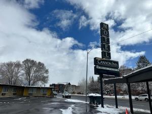 a sign for a gas station with snow on the ground at Canyon Inn Flagstaff in Flagstaff