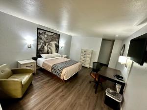 a bedroom with a bed and a chair and a desk at Canyon Inn Flagstaff in Flagstaff