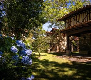 a garden with blue flowers in front of a house at Casitas Del Huerto in La Alberca