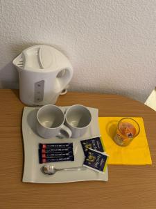 einen Tisch mit Kaffeemaschine und zwei Tassen darauf in der Unterkunft Stadtoase im Herzen Berlins in Berlin