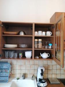 a kitchen with wooden cabinets with plates and dishes at Appartement-Vierzon-centre in Vierzon +10 photos
