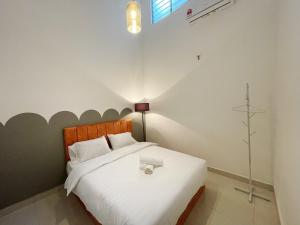 una camera da letto con un letto con una croce sul muro di Bandar putra Ktv Snooker BBQ/IOI Mall/JPO/Aeon/Senai Airport/Kulai a Kulai Altre 18 foto