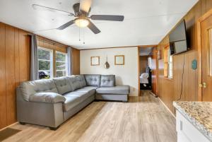 Ocala Farm Lake House في Ocklawaha: غرفة معيشة مع أريكة ومروحة سقف