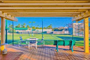 un patio con tavolo, sedie e campo da baseball. di Summer House On Romar Beach a Orange Beach