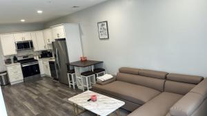 ein Wohnzimmer mit einem Sofa und einer Küche in der Unterkunft The Stylish Suite - 1BR with Free Parking in Paterson