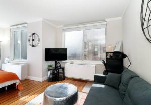 ein Wohnzimmer mit einem Sofa und einem TV in der Unterkunft Lovely Studio Apartment in NYC in New York