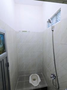 y baño con ducha y aseo. en Bunda House Syariah Lapai, en Padang
