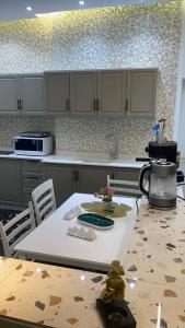 a kitchen with a table and a counter top at شقة مفروشة راقية in Al Ḩawīyah