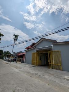 un edificio con una puerta amarilla en una calle en Bunda House Syariah Lapai en Padang