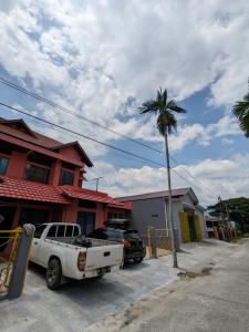 un camión estacionado frente a una casa con una palmera en Bunda House Syariah Lapai en Padang