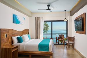 a bedroom with a bed and a view of the ocean at Cristalino Lagoon Front Hotel, Restaurant & Spa in Bacalar +42 photos