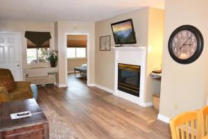 鸽子谷River Place Condos #401 2BD的客厅设有壁炉和墙上的时钟