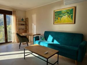 salon z niebieską kanapą i stołem w obiekcie Villa Risan Apartments w mieście Risan