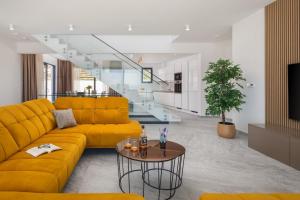 sala de estar con sofá amarillo y mesa en NEW! Villa Brilliance heated pool 50 m2, sea view, en Vranjic