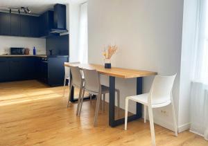 een eettafel met witte stoelen in een keuken bij Charmant appartement rénové au cœur de Concarneau in Concarneau